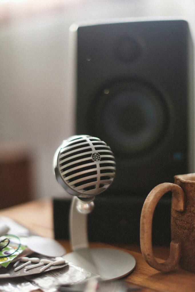Retro-style microphone and speaker setup on a wooden table, capturing a cozy, vintage vibe.