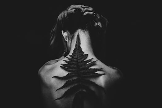 pexels-photo-573294-573294 Black and white photo of a tattooed woman from the back, featuring a fern design. Captivating and artistic pose.