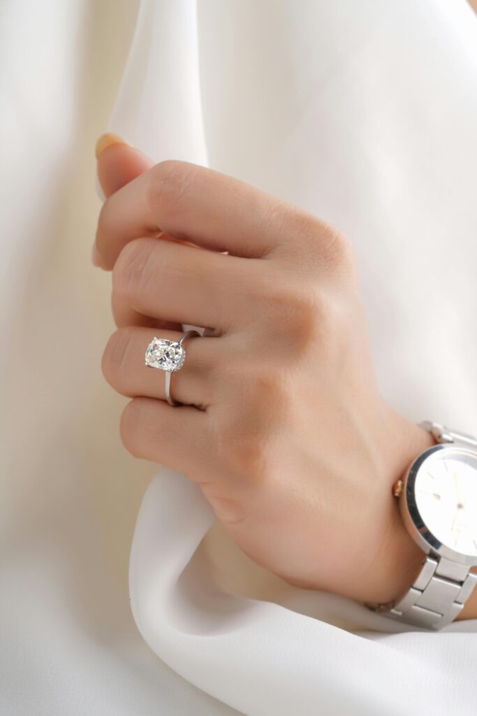 Close-up of a hand wearing a diamond ring and stylish wristwatch, showcasing elegance.